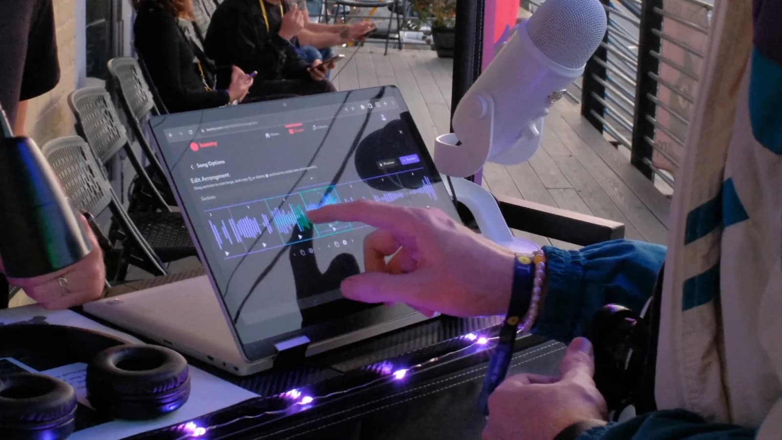 Boomy workspace showing a user's hand interacting with the song arrangement editor in a dark mode interface.