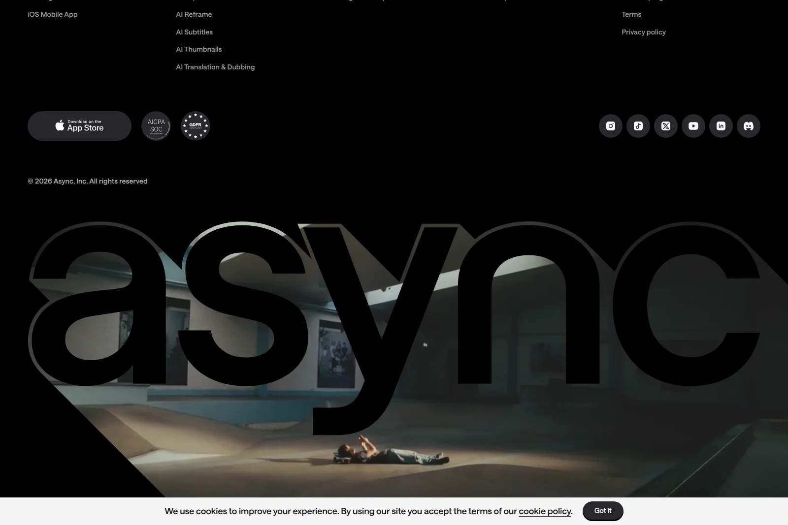 Async landing page showing its brand name 'async' overlaid on a cinematic background with footer links in a dark-mode aesthetic.